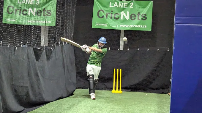 A batter practising a shot in an indoor cricket net. CC0 sample; not Tailor academy photography.